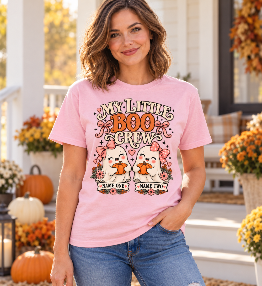 Illustrative lifestyle mockup: My Little Boo Crew personalized Halloween shirt with two name placeholders, Light Pink, worn by an adult woman.